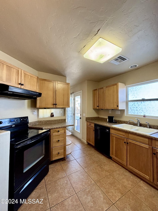 kitchen featuring light tile patterned floors, sink, plenty of natural light, and black appliances