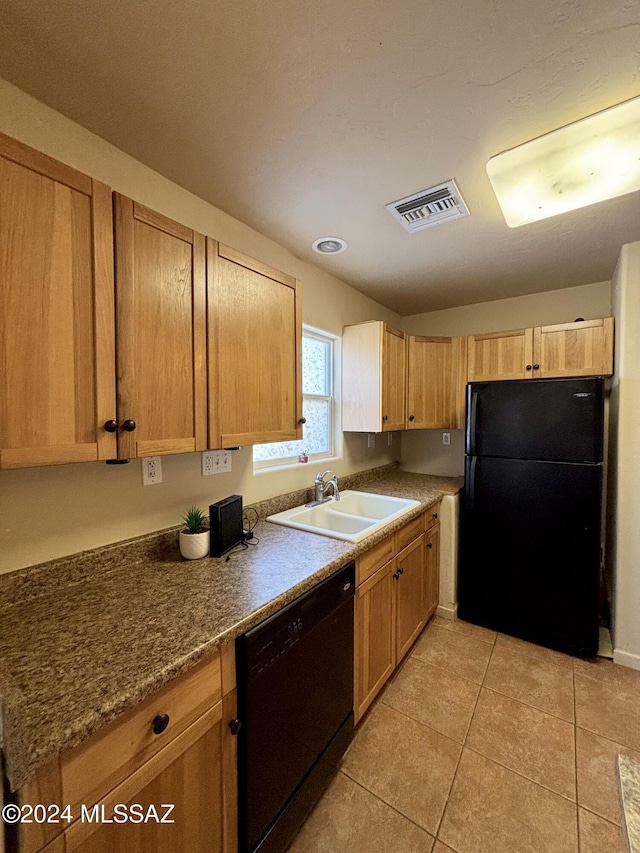 kitchen featuring black appliances, light tile patterned floors, sink, and light brown cabinetry