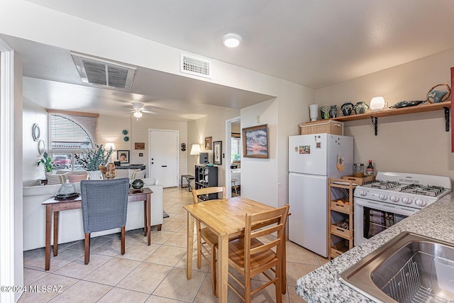 kitchen with white appliances, ceiling fan, and light tile patterned flooring