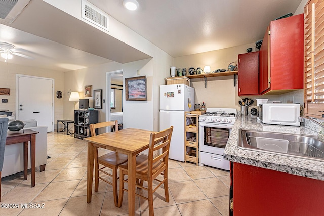 kitchen featuring ceiling fan, sink, light tile patterned flooring, and white appliances