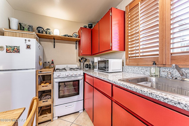 kitchen with white appliances, sink, and light tile patterned floors