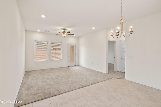 spare room with light carpet and ceiling fan with notable chandelier