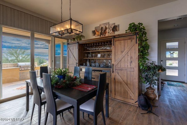 dining room featuring wood-type flooring and an inviting chandelier