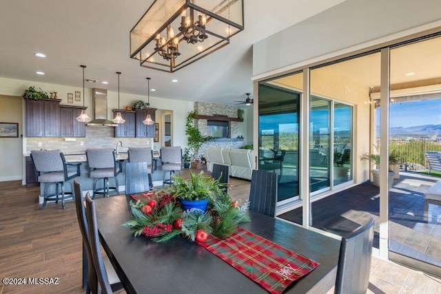 dining area with hardwood / wood-style floors and ceiling fan with notable chandelier