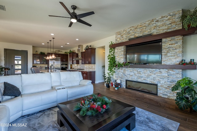 living room featuring a fireplace, ceiling fan, dark hardwood / wood-style flooring, and sink