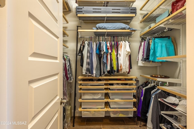 walk in closet with dark wood-type flooring