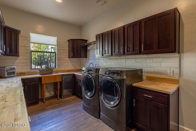 clothes washing area with dark hardwood / wood-style flooring, cabinets, and independent washer and dryer