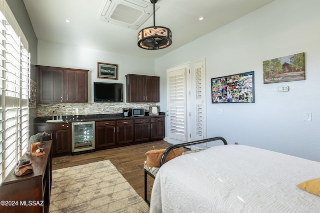 bedroom with wine cooler, dark hardwood / wood-style flooring, and sink