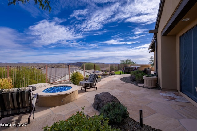 view of patio / terrace featuring a fire pit and a mountain view