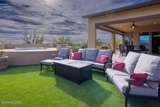 patio terrace at dusk featuring an outdoor living space, a hot tub, and a lawn