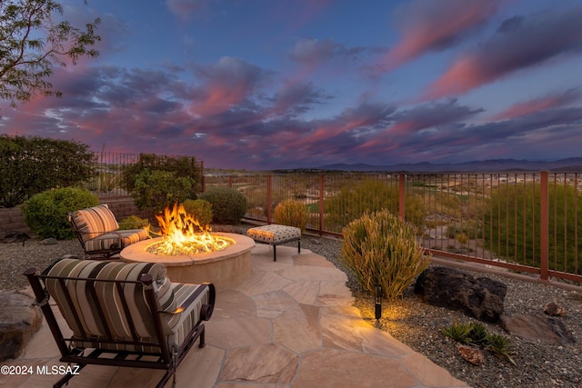 patio terrace at dusk with a mountain view and a fire pit