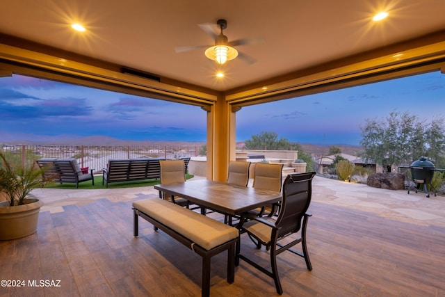 patio terrace at dusk with grilling area and ceiling fan