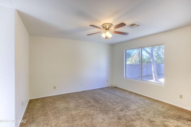 carpeted spare room featuring ceiling fan