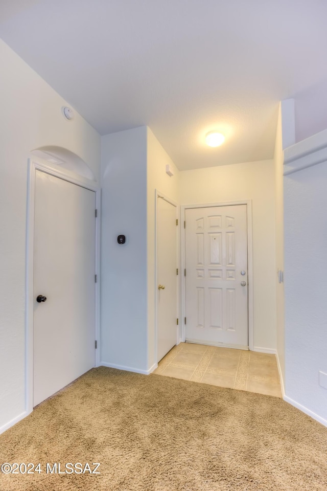 foyer featuring light carpet