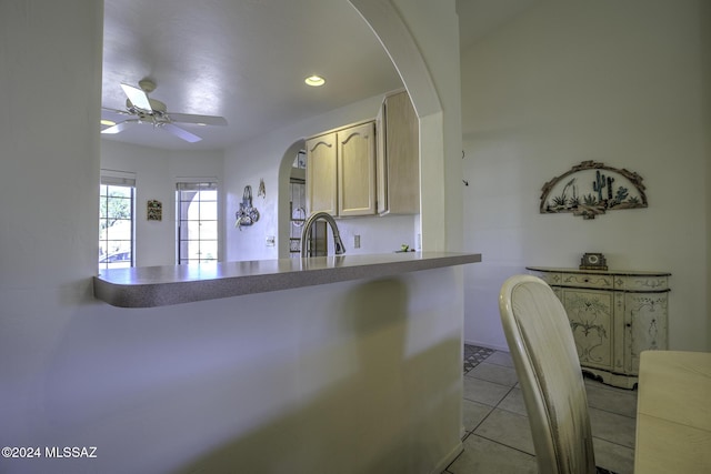 kitchen featuring light tile patterned flooring, ceiling fan, and sink