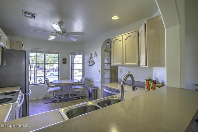 kitchen featuring ceiling fan, sink, light brown cabinets, white stove, and light tile patterned flooring