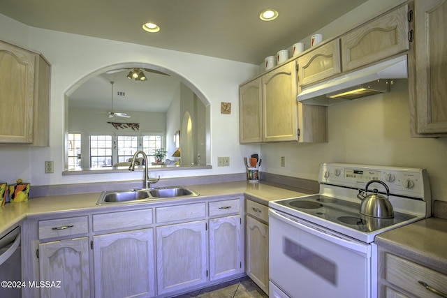 kitchen with light brown cabinetry, sink, and white electric range oven