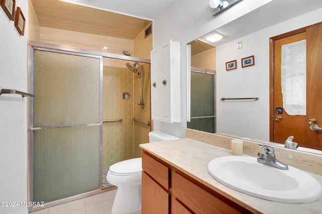 bathroom with tile patterned flooring, vanity, toilet, and walk in shower