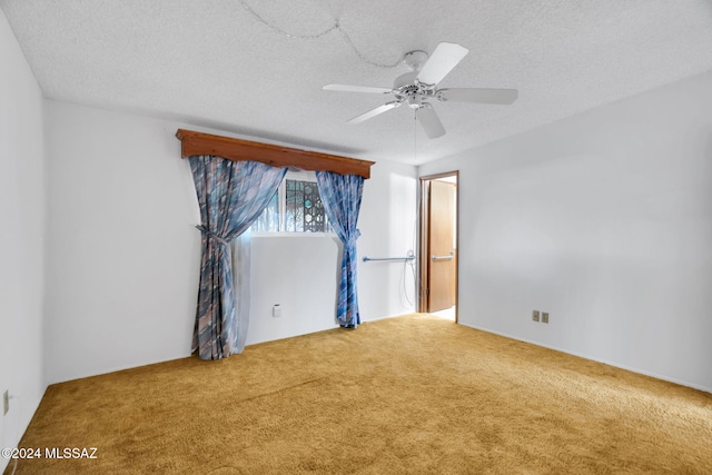 empty room with ceiling fan, carpet, and a textured ceiling