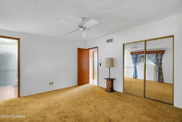 unfurnished bedroom with ceiling fan, carpet floors, a closet, and a textured ceiling