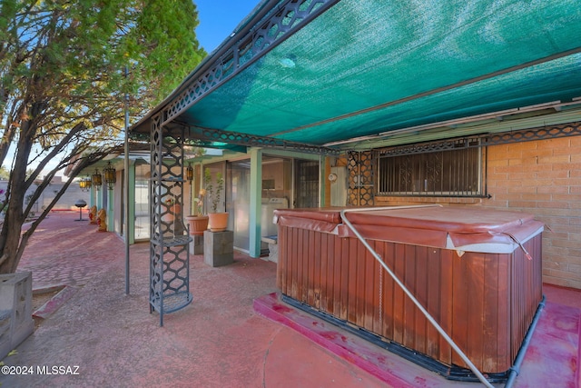 view of patio with a hot tub and washer / dryer