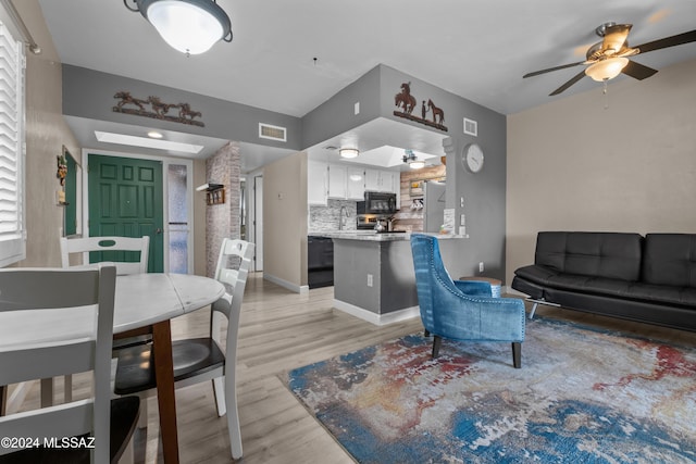 living room with light hardwood / wood-style flooring and ceiling fan