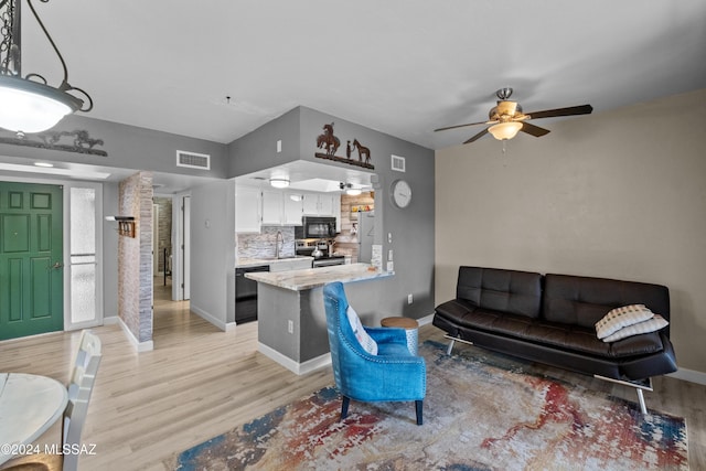 living room featuring light hardwood / wood-style flooring, ceiling fan, and sink