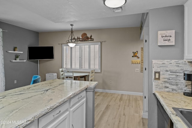 kitchen featuring tasteful backsplash, light hardwood / wood-style flooring, white cabinets, and pendant lighting