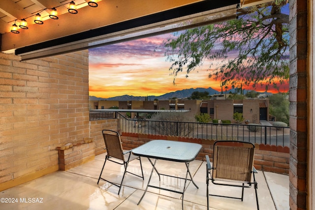 balcony at dusk featuring a mountain view