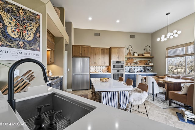 kitchen with hanging light fixtures, stainless steel appliances, tasteful backsplash, a notable chandelier, and light tile patterned floors