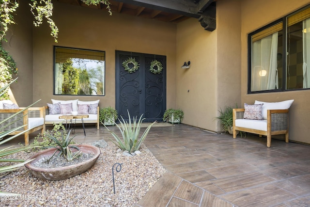 view of exterior entry with a patio area and an outdoor hangout area