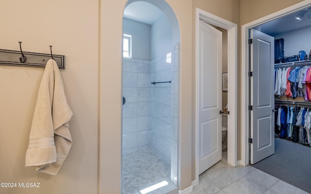 bathroom featuring tiled shower and tile patterned floors