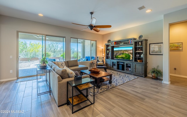 living room with ceiling fan and light hardwood / wood-style flooring