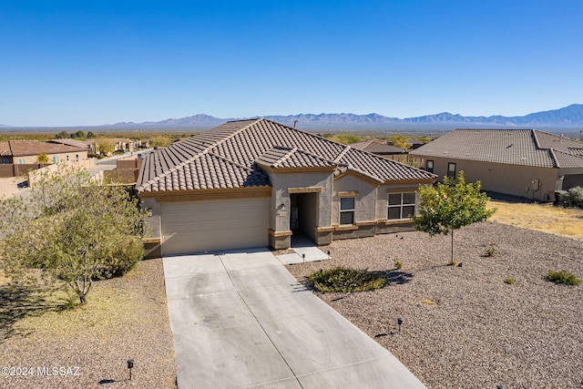 view of front of property with a garage and a mountain view