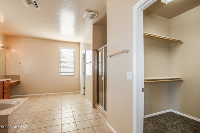 bathroom with a shower with door, tile patterned floors, and vanity