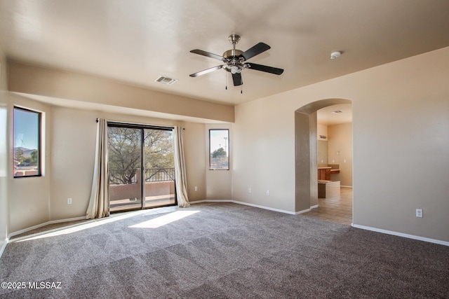 carpeted spare room featuring ceiling fan