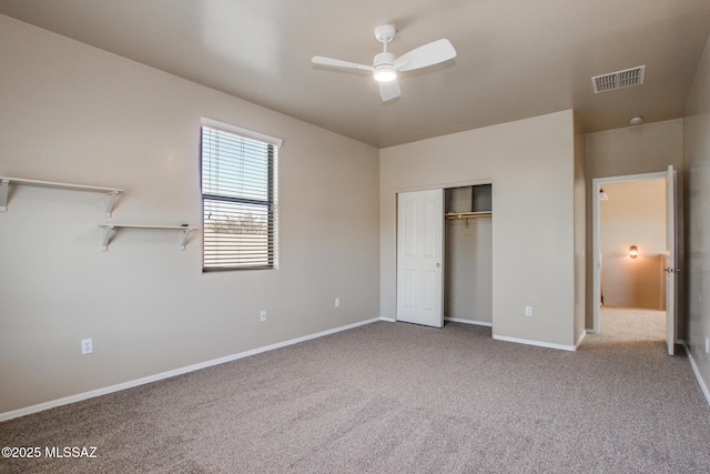 unfurnished bedroom featuring ceiling fan, a closet, and light carpet