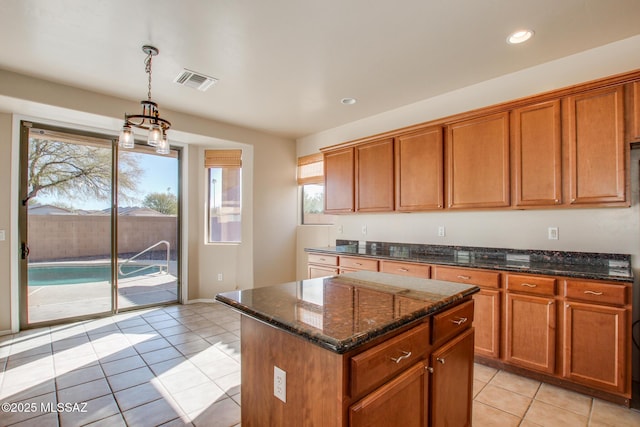 kitchen featuring light tile patterned floors, a kitchen island, plenty of natural light, and hanging light fixtures