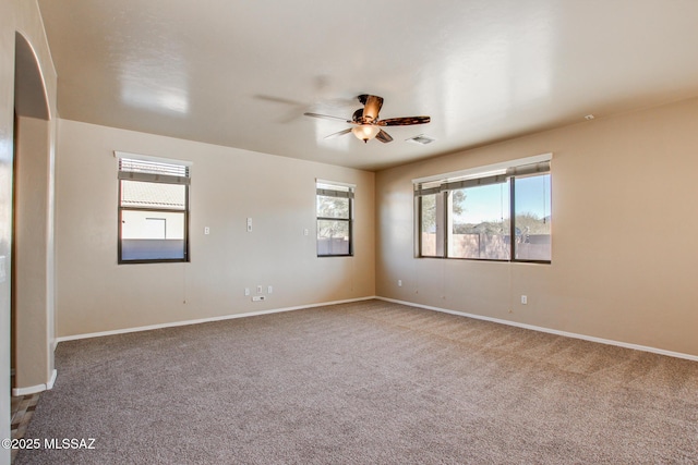 carpeted spare room featuring ceiling fan