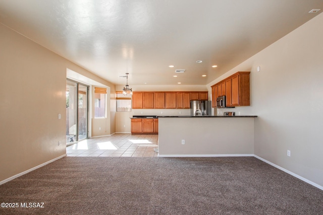 kitchen featuring light colored carpet, pendant lighting, appliances with stainless steel finishes, and kitchen peninsula