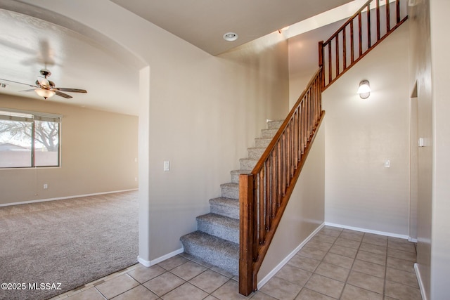 stairway featuring ceiling fan and tile patterned flooring