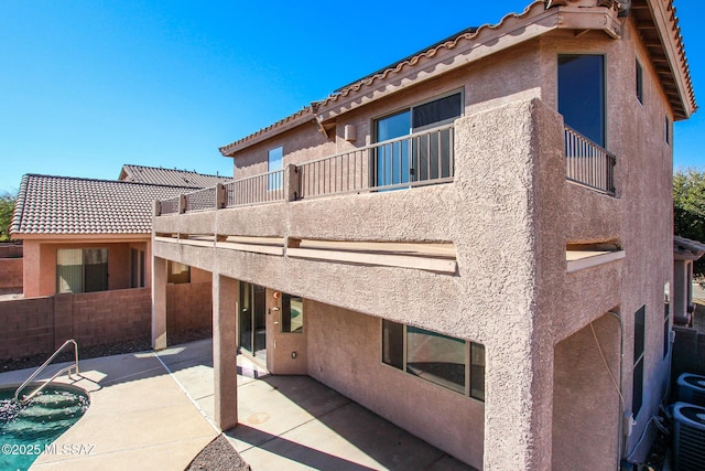 rear view of house with a balcony and a patio