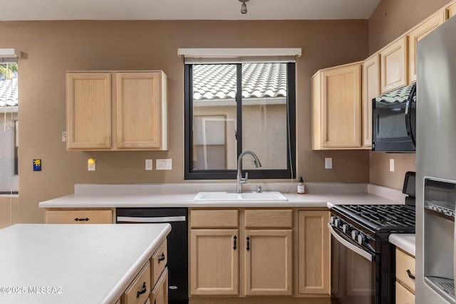 kitchen featuring light brown cabinetry, sink, and black appliances