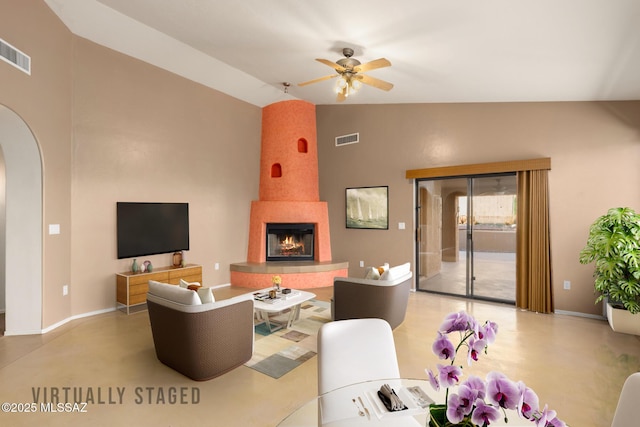 living room featuring ceiling fan, a large fireplace, and lofted ceiling