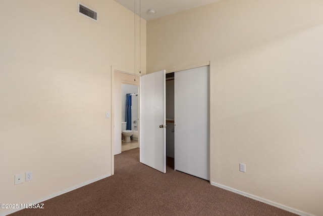 unfurnished bedroom with dark colored carpet