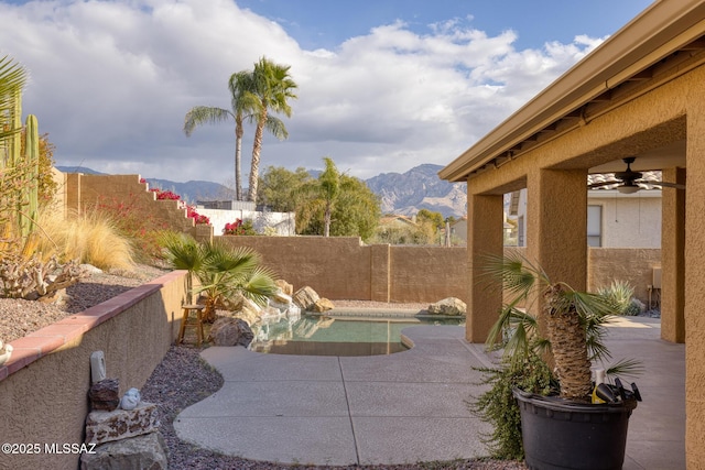 view of patio / terrace featuring a mountain view, a fenced in pool, and ceiling fan