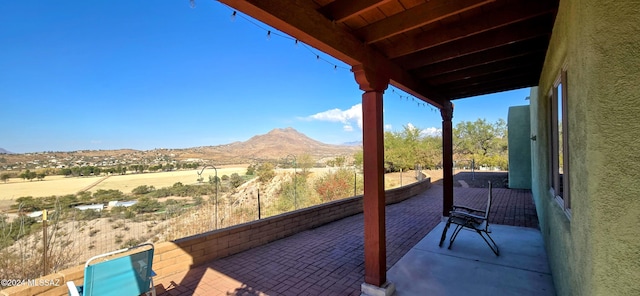 balcony featuring a mountain view, a rural view, and a patio area