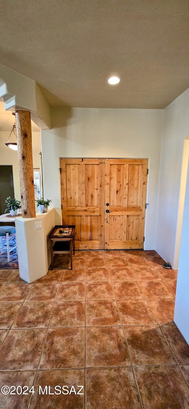 hall featuring tile patterned flooring and a textured ceiling