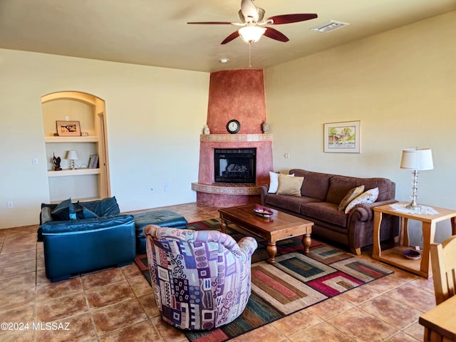 living room featuring tile patterned flooring, ceiling fan, and a fireplace