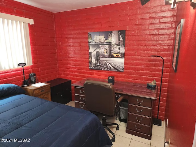 bedroom featuring light tile patterned floors and brick wall